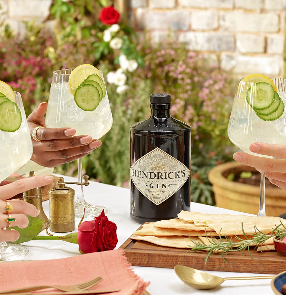 Hendrick's Gin Cucumber Lemonade cocktail people clinking glasses at a summer garden party
